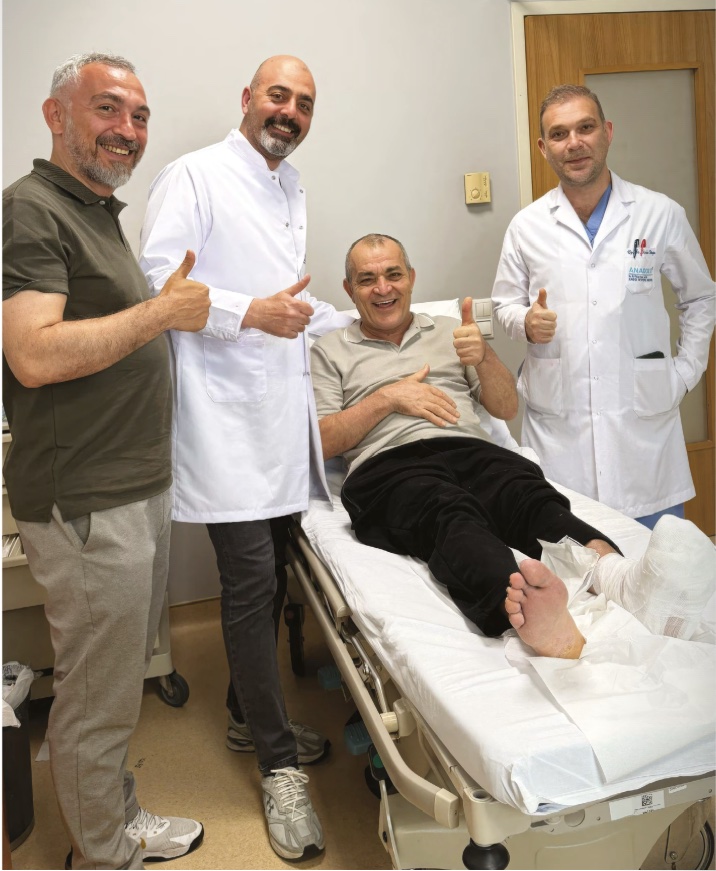 İsmail Doğru with the medical team during treatment, bandaged foot